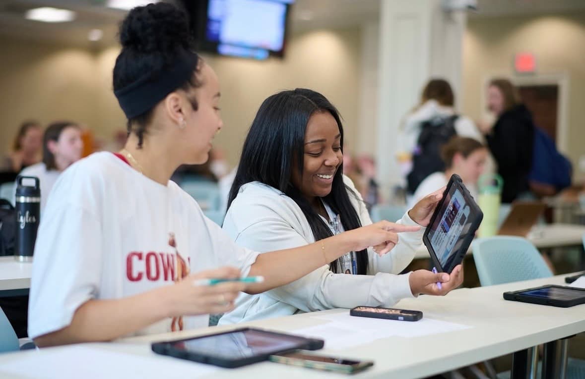 Two nursing students collaborating with SimVS-IV tablets in educational setting